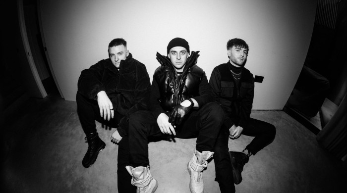Black & White image of three men sat on the ground